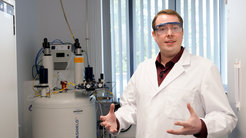 Dr. Stefan Glöggler vor einem NMR Spektrometer.