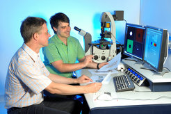 Prof. Dirk Görlich (links) und Dr. Bastian Hülsmann untersuchen die Barriere der Kernpore am Mikroskop.