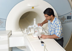 Arun Joseph adjusts the MR-compatible cavity with the enclosed chicken egg between the MR-receiver coils.